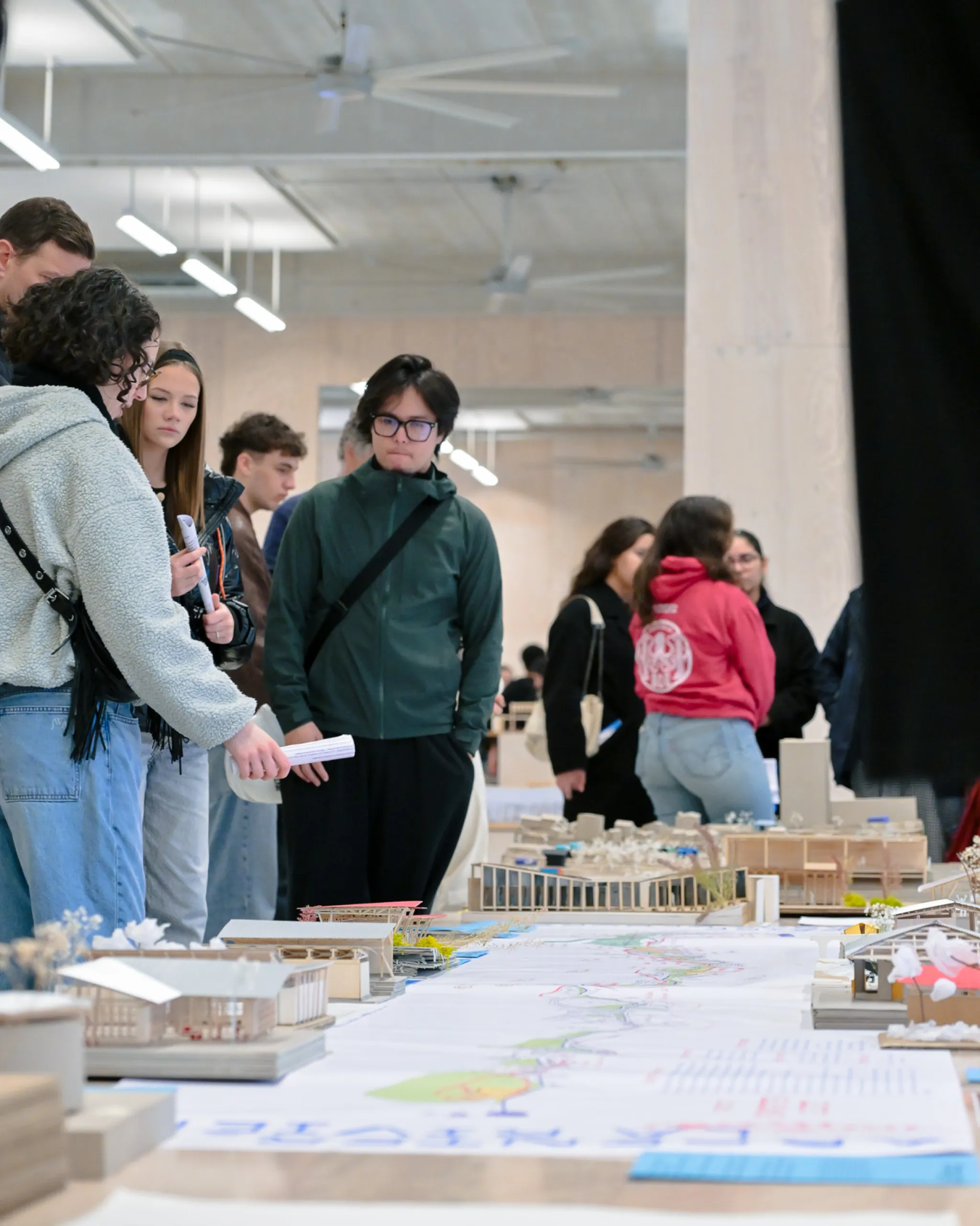 Visiteurs observant les maquettes d'étudiants
