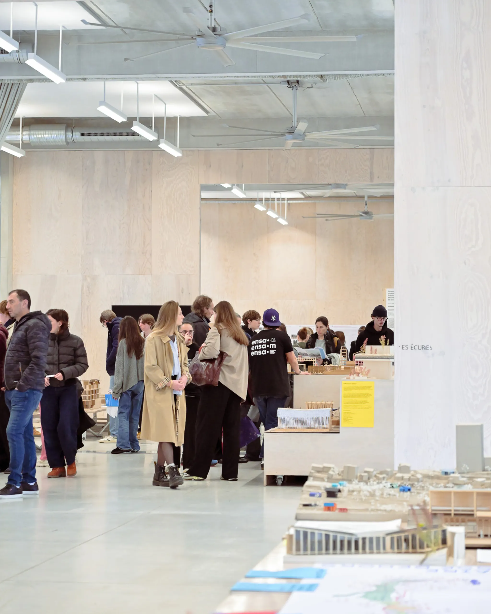 Visiteurs parcourant les maquettes d'étudiants
